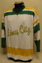 Bogdan Podwysocki #18 1974-75/75-76   These are the second style jersey worn by the Musketeers for 2 seasons. This one was worn by fan favorite Bubba Podwysocki. Originally, these had the traditional circular Tri-State crest. Upon arrival of new Musketeer jerseys for the 76-77 season, these were handed down to the Sioux City High School team, where the front crest was removed and replaced by the generic "Sioux City" logo. Both sets were altered so finding one of these originals w/crest is gonna be a toughie!!!