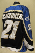 Anthony Canzoneri Sioux Falls Stamepde 2002-03 #21 Worn during the 2002-03 USHL season. Shows great wear. Made by Gemini and is a size 54. NOB, shoulder patches, USHL & Gemini Crest on front. This style of jersey was worn for the first four seasons. 1999-2000 was Sioux Falls' first season in the league.
