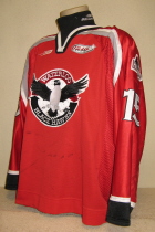 Waterloo BlackHawks #16 2001-02 Red  This one was worn during the 2001-02 season by Zac Headrick. BlackHawk alternate logo patches on shoulders. Bauer and USHL logos on chest. This one has tons of wear as it was used for this and the previous season. Manufactured by SP, it is size 56. 