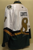  Lious Liotti 2003-04 # 8 White. 25th USHL Aniversary Season Worn during the 03-04 season by Lious Liotti.  This season marked the 25th Anniversary of the USHL. Each team sported the special anniversary patch on home and away jerseys that season. Has alternate shoulder patches and USHL crest on front.  This was the last season of the SC logo. Manufactured by OT Sports and is a size 56.