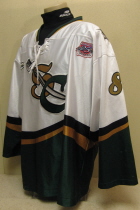  Lious Liotti 2003-04 # 8 White. 25th USHL Aniversary Season Worn during the 03-04 season by Lious Liotti.  This season marked the 25th Anniversary of the USHL. Each team sported the special anniversary patch on home and away jerseys that season. Has alternate shoulder patches and USHL crest on front.  This was the last season of the SC logo. Manufactured by OT Sports and is a size 56.