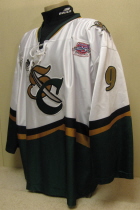 Adam Krug # 9 2003-04 White.  25th USHL Aniversary Season. Worn during the 03-04 season by Adam Krug.  This season marked the 25th Anniversary of the USHL. Each team sported the special anniversary patch on home and away jerseys that season. Has alternate shoulder patches and USHL crest on front.  This was the last season of the SC logo. Manufactured by OT Sports and is a size 56.